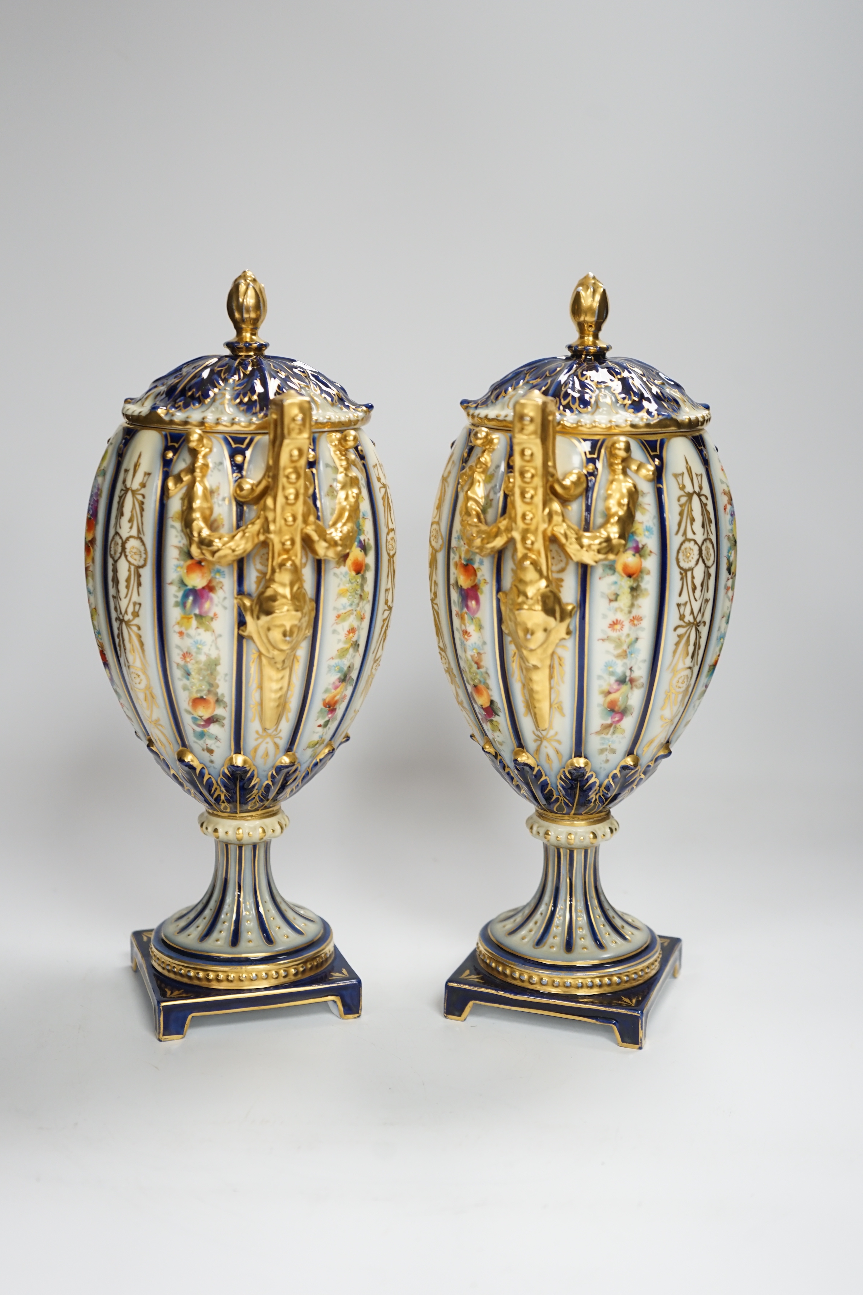 A pair of Rudolstadt gilt decorated urns and covers, 29cm